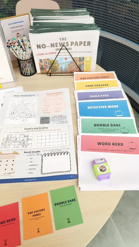 Issue 3 package flat lay — paper, game cards, and pencils