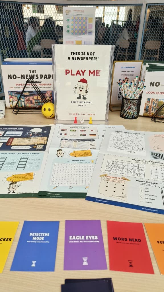 Play table with The No-News Paper, dice, playing pieces, and game cards